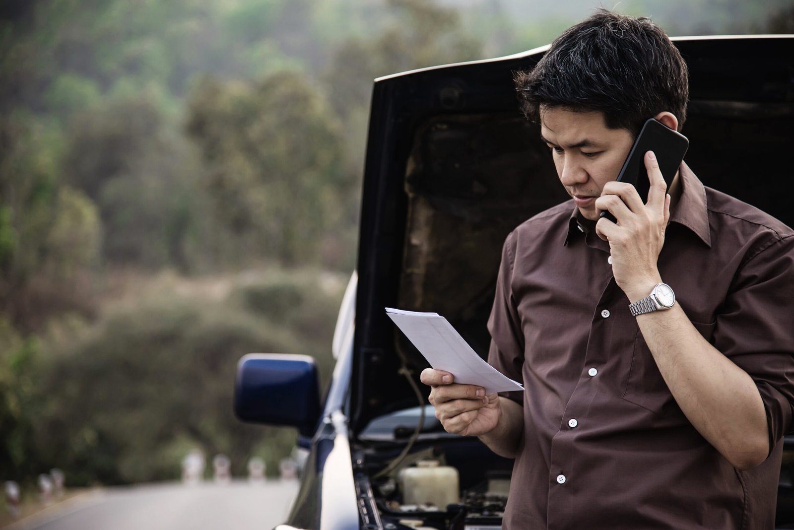 man try fix car engine problem local road scaled
